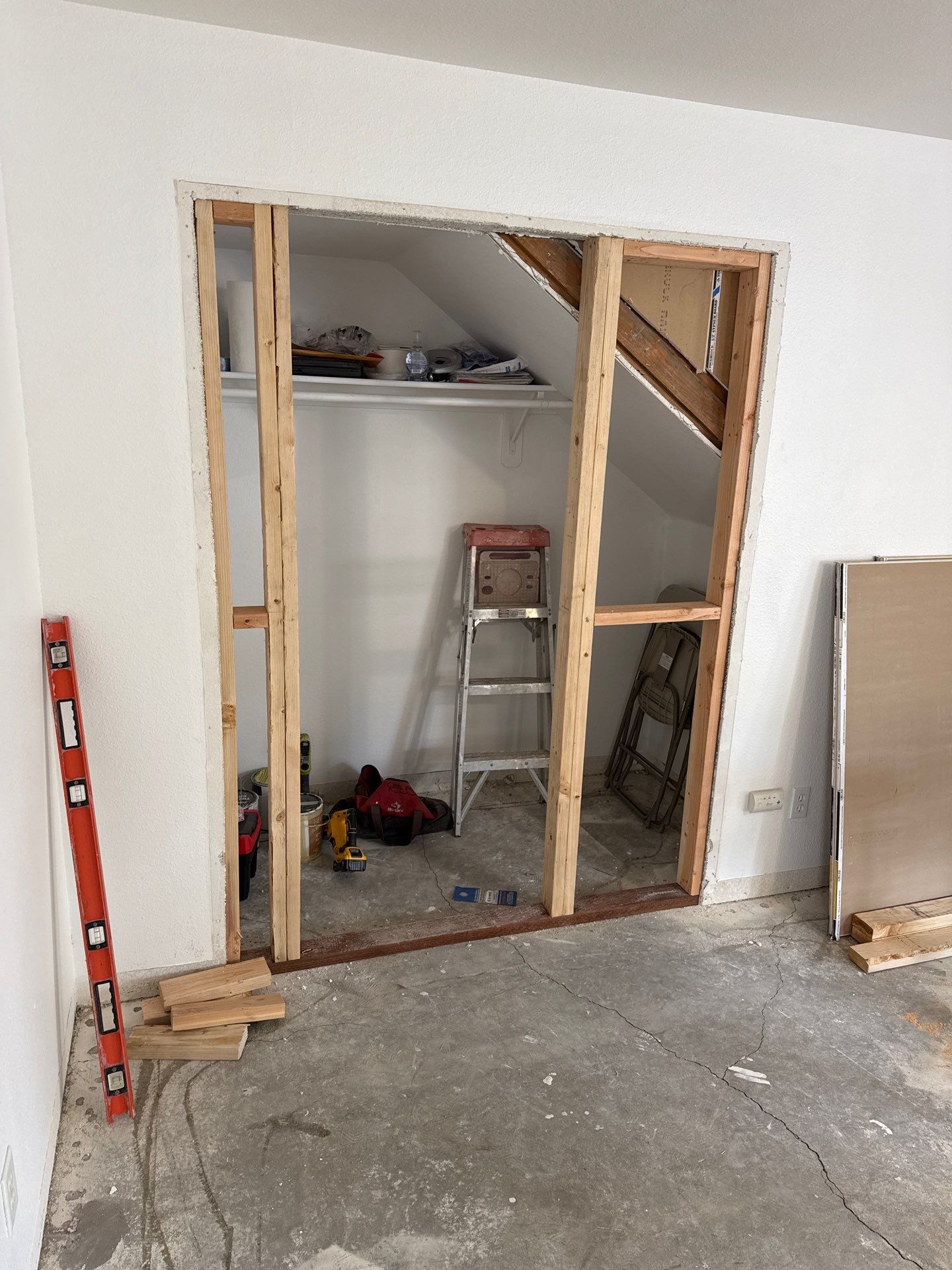 Construction: new wall framing with the orange level visible