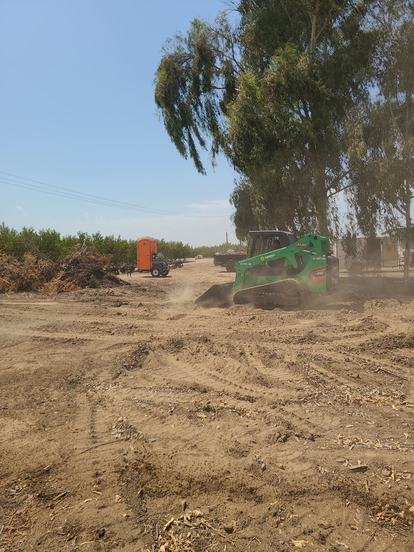 Skid steer grading the pad and prepping the site