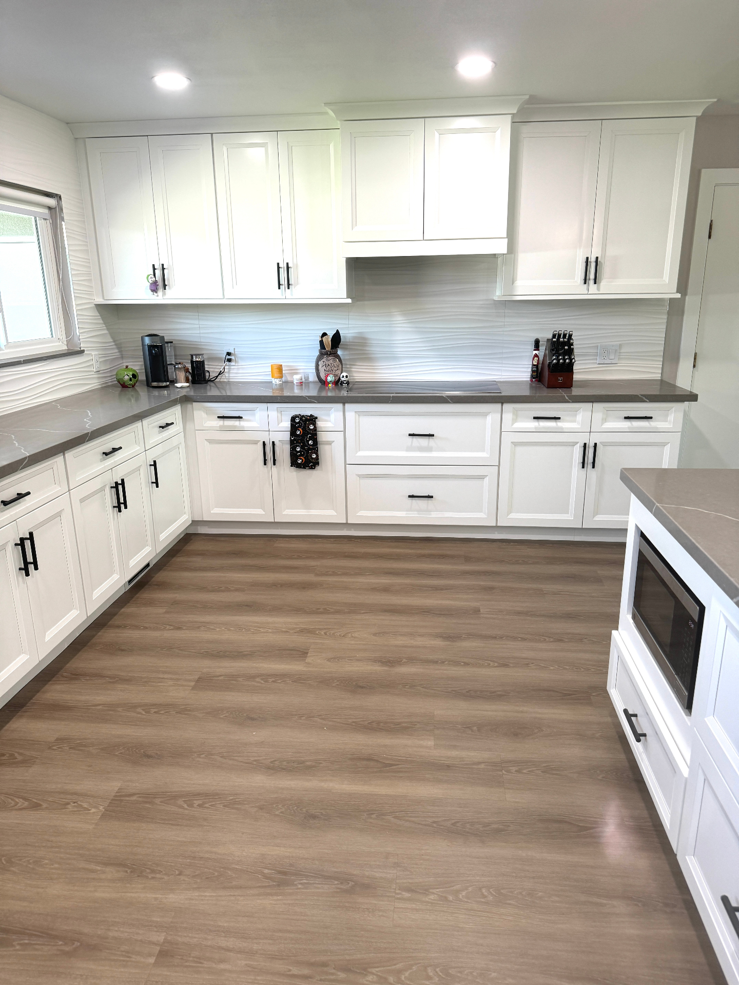 Finished white shaker kitchen with wave-textured backsplash and gray quartz counters